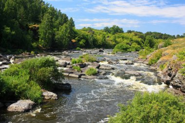 Gri büyük kayalar bir dağ nehrinde yatıyor.