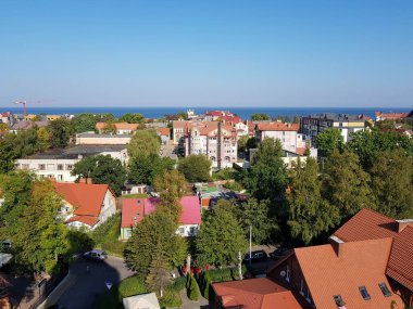 Mavi deniz çatıların üzerinde görünür.