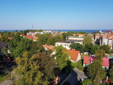 Mavi deniz çatıların arkasında görülebilir.