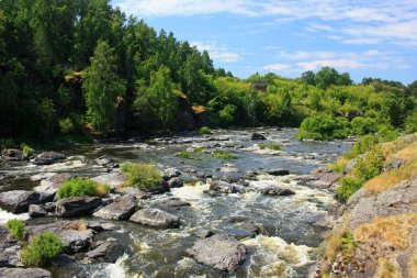 Dağ nehrinde gri büyük kayalar var.