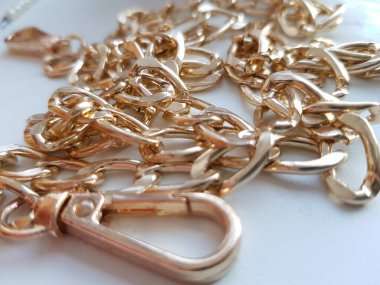 Masanın üzerinde parlak altın bir zincir var.