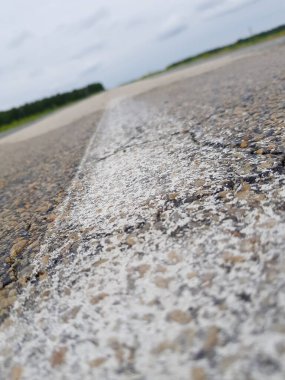 Asfalt yolda aşınmış beyaz izler.