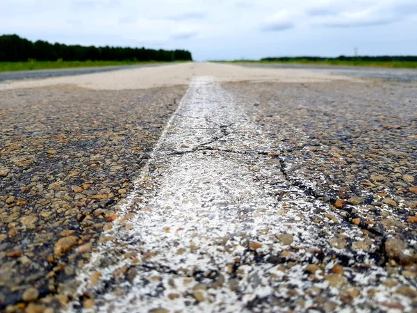 緑のフィールドに空のアスファルト道路 — ストック写真