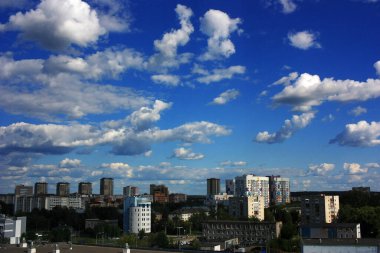 Şehrin üstündeki mavi gökyüzünde beyaz bulutlar