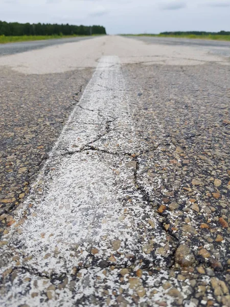 緑のフィールドに空のアスファルトの道路 — ストック写真