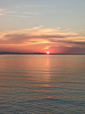 Batan güneş ufkun ötesindeki denize batıyor.