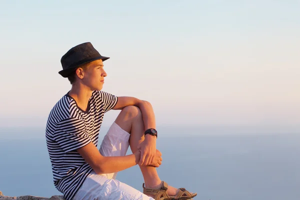 Portret van ernstig en nadenkend jongeman op avondrood achtergrond — Stockfoto