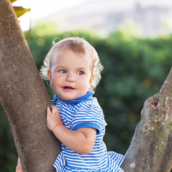Little beautiful pretty happy girl sitting on  tree — Stock Photo, Image