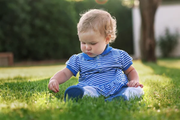 Little beautiful pretty happy girl sitting on grass — Stock Photo, Image