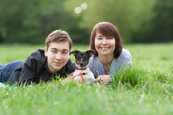 Portret szczęśliwy mather z synem i psem Jack Russell w lato park — Zdjęcie stockowe