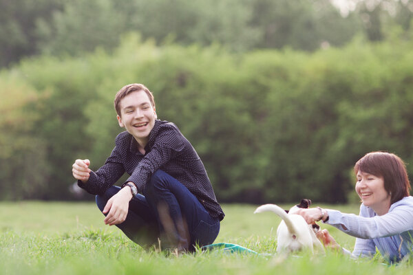 Portrait of happy mather with son and dog Jack Russell in summer park