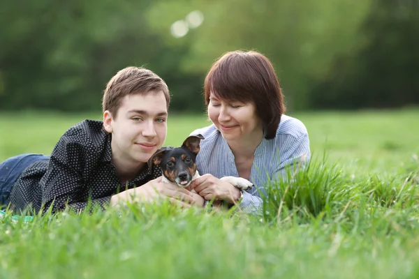 Porträtt av glad mather med son och hund Jack Russell i sommaren park — Stockfoto