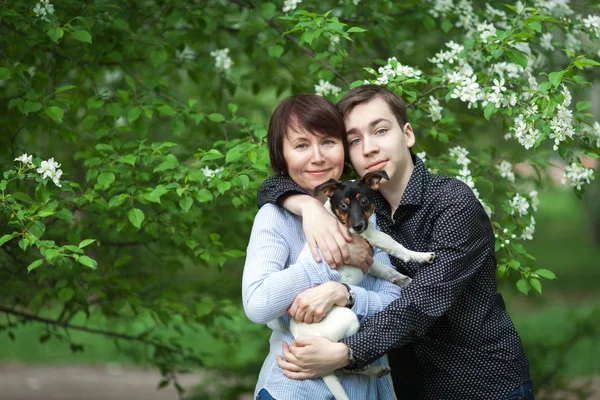 Портрет счастливой матери с сыном и собакой Джеком Расселом в летнем парке — стоковое фото