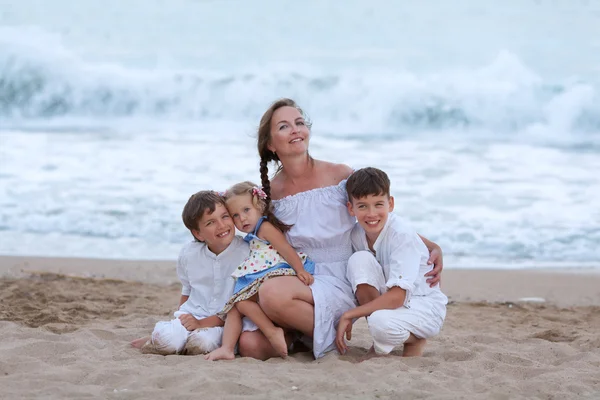 Retrato de mãe alegre e feliz e filhos na praia — Fotografia de Stock