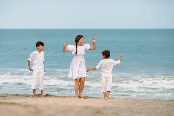Retrato de uma mãe alegre e feliz e filhos na praia — Fotografia de Stock