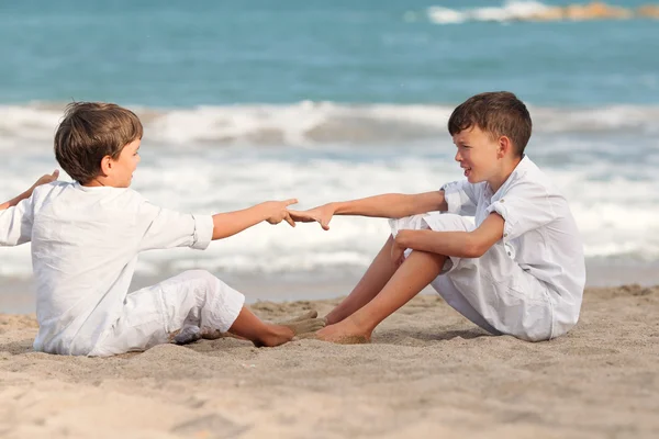 Счастливые братья, играющие на пляже, Испания — стоковое фото