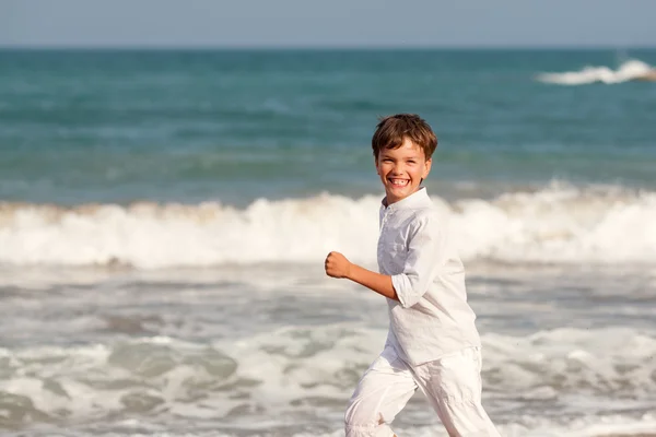 Lycklig pojke leker på stranden, Spanien — Stockfoto