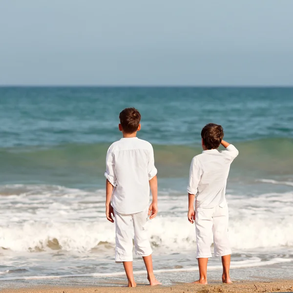 Mutlu kardeşler deniz arka plan üzerinde beyaz gömlek portresi — Stok fotoğraf