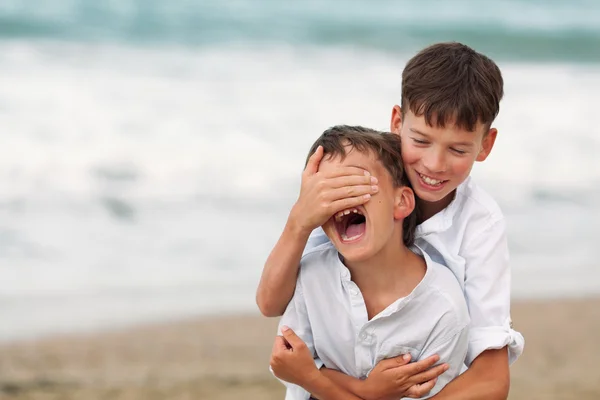 Retrato de hermanos felices en camisas blancas sobre fondo de mar — Foto de Stock