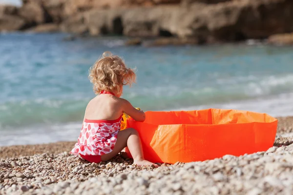 Pequeña chica bonita se baña en la piscina infantil en la costa mediterránea . — Foto de Stock