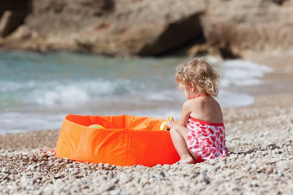 Pequena menina bonita banha na piscina de remo na costa do Mediterrâneo . — Fotografia de Stock