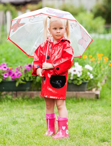Sério pensativo menina bonita em capa de chuva vermelha com guarda-chuva — Fotografia de Stock