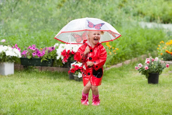 Happy fun vrij klein meisje in de rode regenjas met paraplu lopen in de zomer van het park — Stockfoto