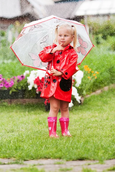 Ciddi dalgın sevimli küçük kız şemsiye ile kırmızı yağmurluk içinde — Stok fotoğraf