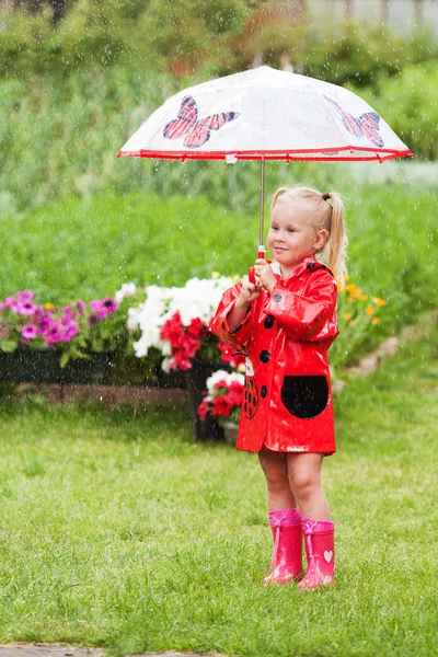 Ernsthafte nachdenkliche hübsche kleine Mädchen in rotem Regenmantel mit Regenschirm — Stockfoto