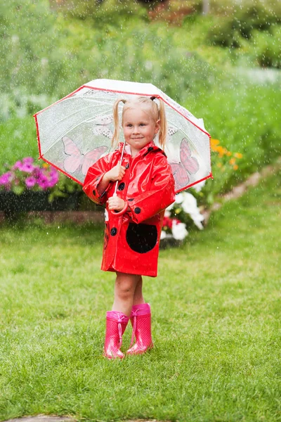 Ernstig nadenkend vrij klein meisje in de rode regenjas met paraplu — Stockfoto