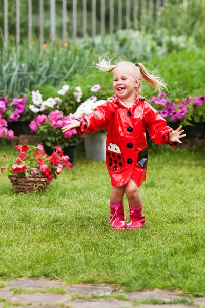 Diversão feliz menina bonita em capa de chuva vermelha com guarda-chuva andando no verão parque — Fotografia de Stock