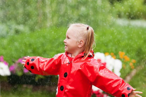Diversão feliz menina bonita em capa de chuva vermelha com guarda-chuva andando no verão parque — Fotografia de Stock