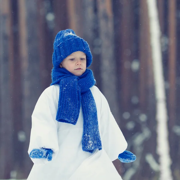 Gelukkige jongen in kostuums sneeuwpop wandelen in winter woud, — Stockfoto
