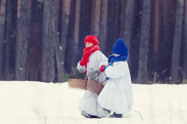 快乐的弟弟和妹妹在服装雪人在冬季森林散步, — 图库照片