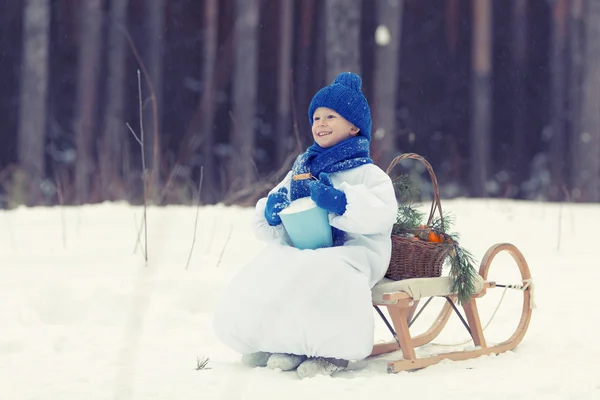 Gelukkige jongen in kostuums sneeuwpop wandelen in winter woud, — Stockfoto