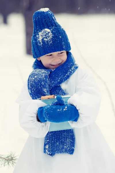 Menino feliz em trajes boneco de neve andando na floresta de inverno , — Fotografia de Stock