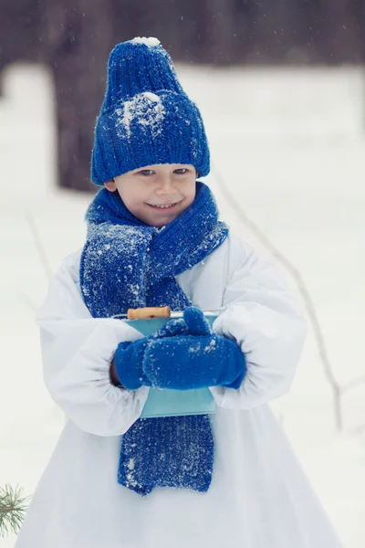 Niño feliz en trajes muñeco de nieve caminando en el bosque de invierno , — Foto de Stock