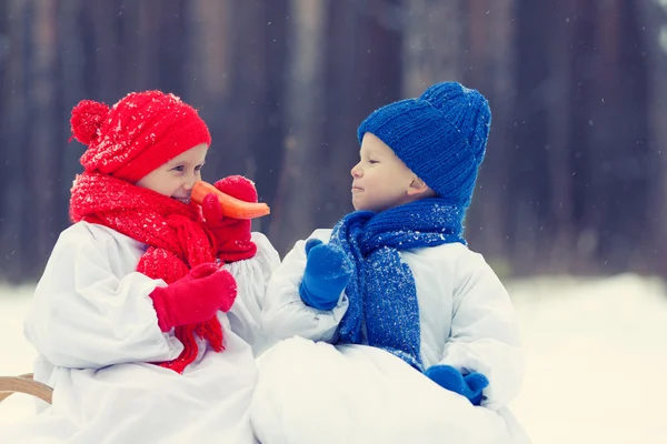 Feliz irmão e irmã em trajes boneco de neve andando na floresta de inverno — Fotografia de Stock