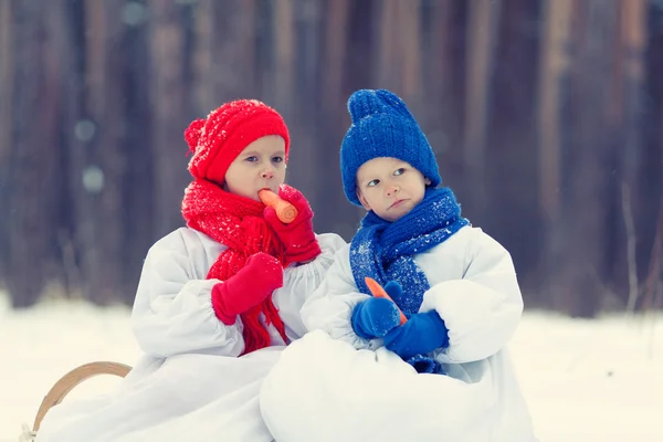 Happy brother and sister in costumes snowman walking in winter forest — Stock Photo, Image