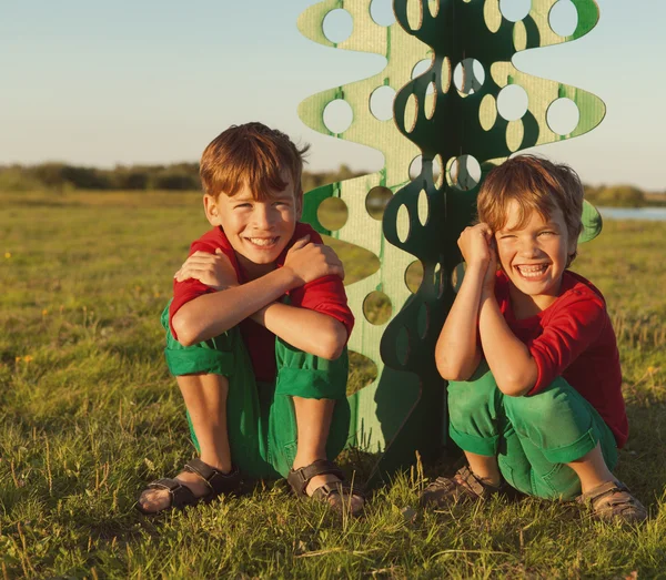 Irmãos felizes estão brincando com árvore de papel — Fotografia de Stock