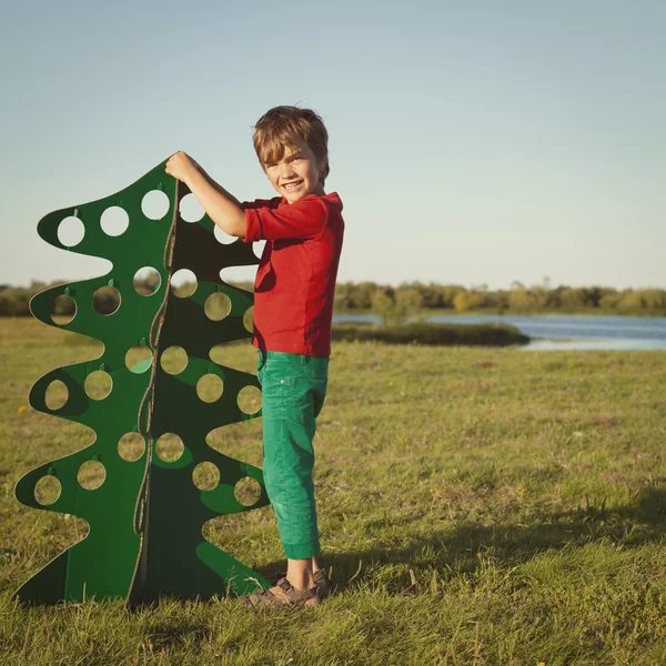 Glücklicher Junge, der mit Papierbaum spielt — Stockfoto