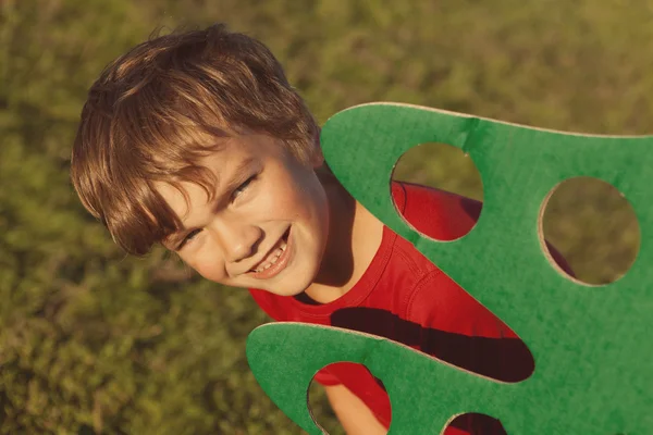 Щасливий хлопчик грає з паперовим деревом — стокове фото