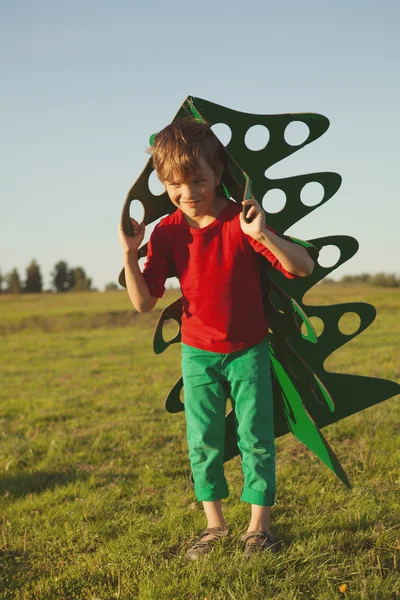 Menino feliz brincando com árvore de papel — Fotografia de Stock