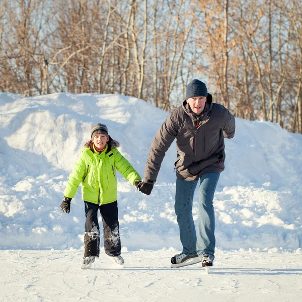 Diversão feliz pai e filho aprendendo a patinar, inverno, ao ar livre — Fotografia de Stock