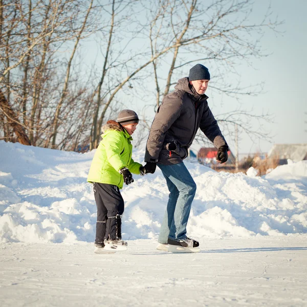 Szczęśliwy zabawa ojca i syna nauki do skate, zima, odkryty — Zdjęcie stockowe