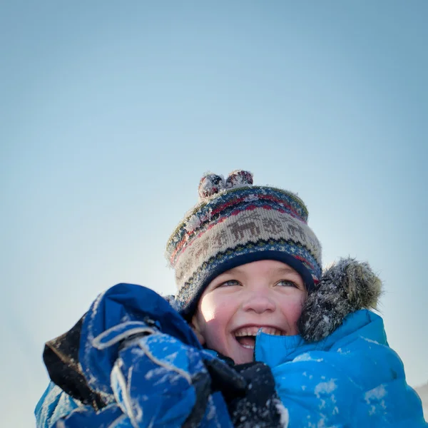 Lyckligt barn i winterwear skrattar medan du spelar i snödriva — Stockfoto