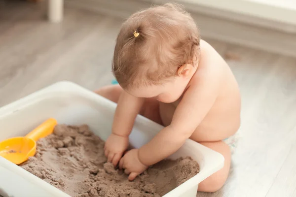 Meisje spelen met zand op de vloer — Stockfoto