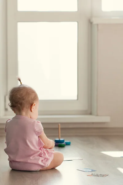 Menina brincando com pirâmide no chão — Fotografia de Stock