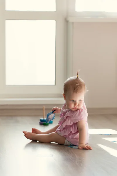 Menina brincando com pirâmide no chão — Fotografia de Stock