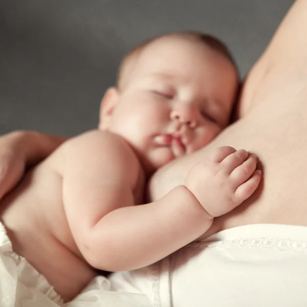 Palma di bambina sul seno di madre — Foto Stock